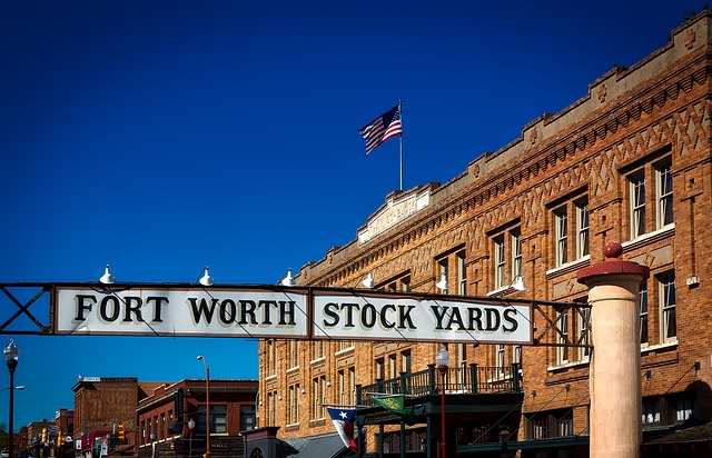 Fort Worth Stock Yards sign over the street with buildings in the background